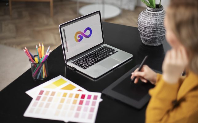 female-logo-designer-working-her-tablet-connected-laptop female-logo-designer-working-her-tablet-connected-laptop